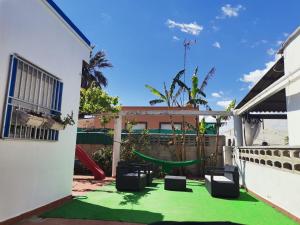 Mareny BarraquetasLa Caseta de Jose的后院铺有绿色地毯,设有游乐场