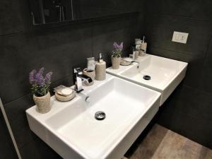 米兰LA CORTE LUXURY APARTMENT的浴室里装有鲜花的白色水槽