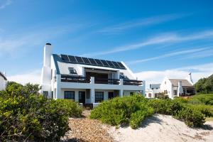 帕特诺斯特Gonana Guesthouse的海滩上带太阳能电池板的房子