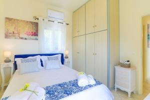 帕拉马Villa Seasunrise的卧室配有蓝色和白色的床,提供毛巾