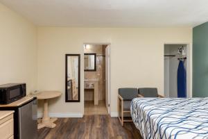 埃尔科Stay Express Inn Elko的酒店客房带一张床、一张桌子和椅子