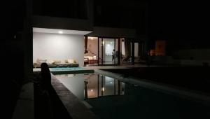 蓬塔穆赫雷斯Villa Sama的一座晚上设有游泳池的房子