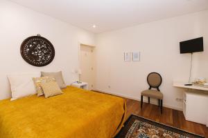 阿尔瓦伦加Casa do Passadiço - Alvarenga的一间卧室配有一张床和一把椅子