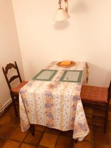 MettetLe charme de l’Estroit的一张桌子,上面有一张桌子布,上面有两把椅子
