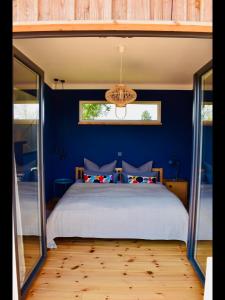 SchwarzFerienhaus M&M的一间卧室配有一张带蓝色墙壁的大床