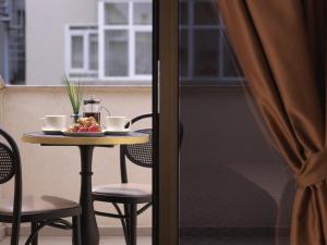 伊斯坦布尔Jaff Hotels & Spa Nisantasi的一张桌子,上面放着一碗水果和两杯