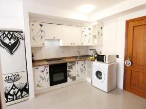厄尔梅达诺Alquilaencanarias-Medano, Cabezo beach, sea views!的厨房配有白色橱柜、洗衣机和烘干机