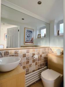 TangmereBright & Cosy - Jacuzzi - Log Burner - King Beds的一间带水槽、卫生间和镜子的浴室