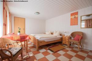 于克里茨Kleiner Bungalow - Zum Strand 50m的卧室配有一张床和一张桌子及椅子