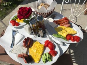 斯库台InTown Guesthouse Shkoder的两盘早餐食物,放在带玫瑰的桌子上