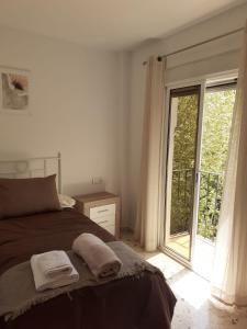 皮诺斯赫尼尔Apartamentos Pinos Genil的一间卧室设有一张床和一个滑动玻璃门
