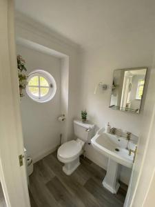 圣玛丽Country cottage with private garden close to beach的白色的浴室设有卫生间和水槽。