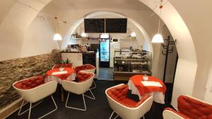 ŽluticeH@M Penzion的餐厅设有白色和橙色的椅子和柜台