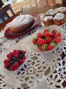 特罗法雷洛富鲁迪洛斯农家乐的桌子上放有草莓、蓝莓和糕点的盘子