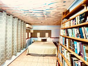 Blow HoleCool Premier Apts. - Airport/SGU的一间卧室设有一张床和一个书架