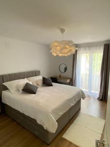 DrinovciCountry House Peace的卧室配有一张白色大床和吊灯。