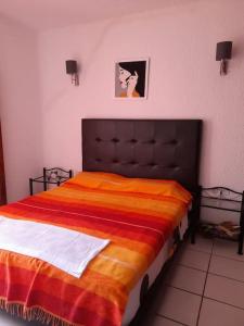 弗尼迪克bel appart refait à neuf sur Tamouda Bay Tétouan的一间卧室配有一张带橙色毯子的大床