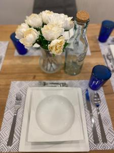 莱奥本#lowcosthighcomfort的一张桌子,上面有盘子和白色花瓶