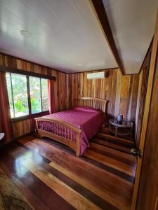 卡维塔Casa Numú的卧室配有一张床铺,位于带木墙的房间内
