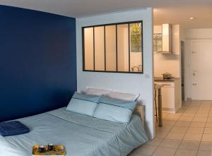 卡奥尔Studio Cosy Cahors- proche Gare et Centre-Ville的一间卧室配有一张蓝色墙壁的床