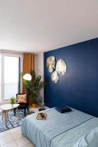 卡奥尔Studio Cosy Cahors- proche Gare et Centre-Ville的蓝色的卧室,配有床和蓝色的墙壁