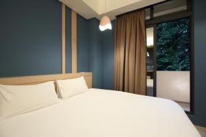 花莲市品 民宿的卧室配有白色的床和窗户。