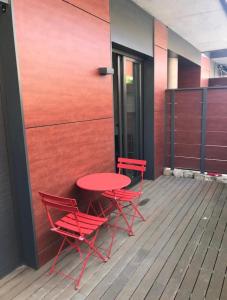 伊瓜拉达Apartamento con encanto的甲板上配有两张红色的椅子和一张桌子