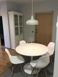 伊瓜拉达Apartamento con encanto的白色餐桌、白色椅子和灯具