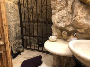 Mi‘ilyāChateau du Roi的石质浴室设有水槽和黑色门