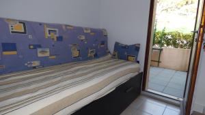 滨海圣皮埃尔Pavillon T2 Mezzanine, Les Frégates, St Pierre la Mer的一间卧室配有蓝色和黄色枕头的床