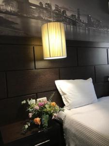 布拉戈耶夫格勒卡迪纳尔酒店的一间卧室配有床、灯和鲜花