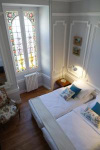 巴涅尔-德吕雄Maison Eugénie的一间卧室设有一张床和一个彩色玻璃窗