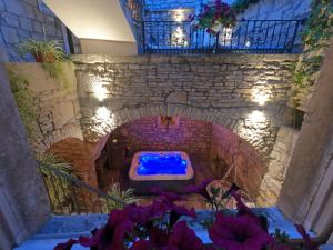 布拉托Stone House Hedonia的浴室设有蓝色的石墙浴缸