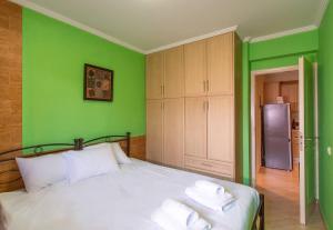 阿特米达Franceska's guest house的绿色卧室,配有带毛巾的床