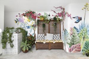 法鲁Le Jardin Secret de Faro Guesthouse的墙上挂着植物的长凳