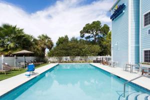夏洛特港Microtel Inn & Suites by Wyndham Port Charlotte Punta Gorda的一座房子的院子内的游泳池