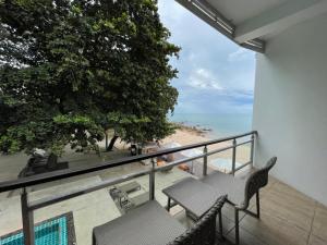 锡春普拉萨恩索克别墅海滩度假村的一个带桌椅和海滩的阳台