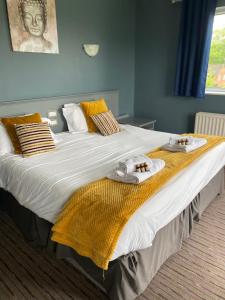 科尔福德贝尔斯酒店的一张大床,配有毛巾和毛巾