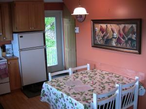 拜圣保罗际遇木屋的厨房配有桌子,墙上挂有绘画作品