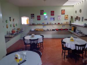 北茹阿泽鲁Pousada Aconchego的一间在房间带两张桌子和椅子的餐厅