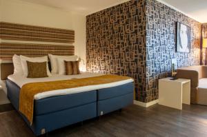 阿姆斯特丹阿不思阿姆斯特丹市中心酒店的一间卧室配有一张大床和一把椅子
