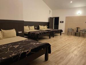 科代卡纳尔RR Holidays - Home Stay的带三张床和桌椅的房间