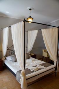 DiakoftiHotel Notara的一间卧室配有带窗帘的天蓬床