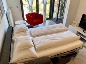 萨格勒布OnPoint的配有红色椅子的客房内的两张床