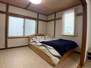 旭川Nagayama Home的一间设有床铺的卧室,位于带窗户的房间内