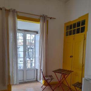 楼尔Historical da Matriz的一间设有黄色门、桌子和窗户的房间