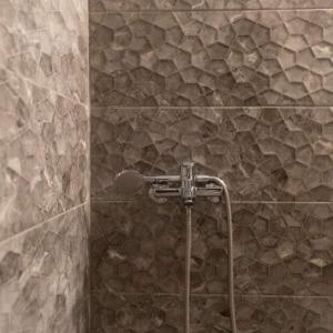 希维利Vaso Manos Apartment - Siviri Chalkidiki的带淋浴的浴室(带石墙)