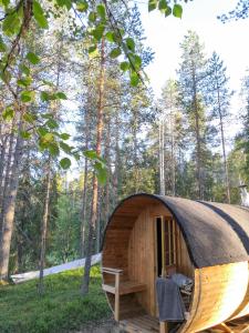 索特AuroraHut Pytkyn Iglu的森林中带茅草屋顶的小木屋