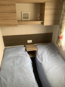 克利索普斯CLJP Caravan Thorpe Park Cleethorpes Free WI-FI的一间卧室配有一张床、一张桌子和一张四柱床。