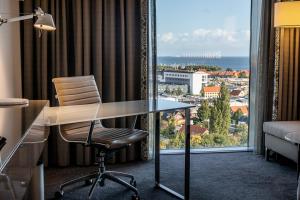哥本哈根哥本哈根机场克拉里昂酒店的一张桌子和椅子,位于带大窗户的房间里